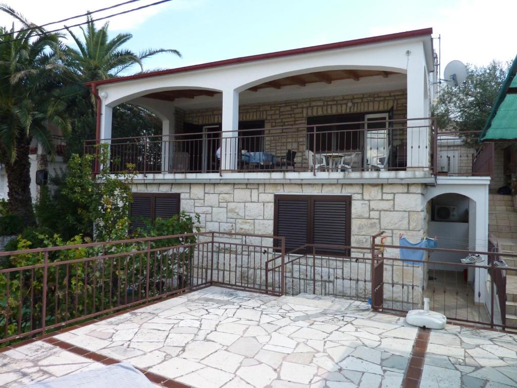 a house with a balcony and a patio at Apartments by the sea Seget Vranjica, Trogir - 976 in Seget Vranjica