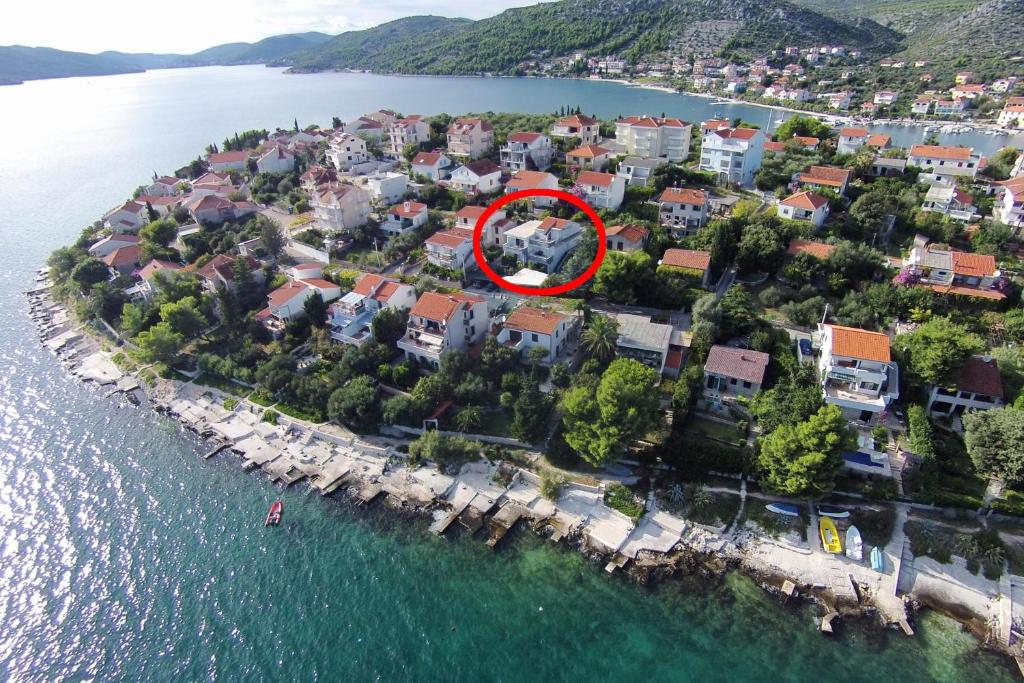 an island with a house in the middle of the water at Apartments by the sea Seget Vranjica, Trogir - 978 in Seget Vranjica