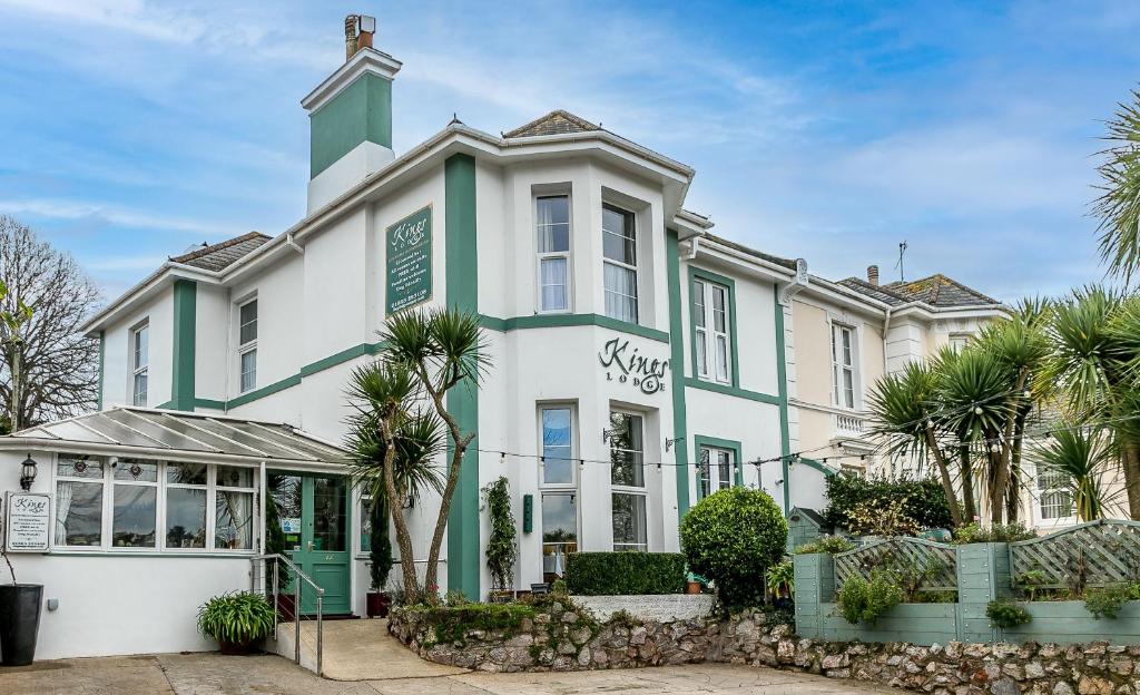 a large white and green building with palm trees at Kings Lodge in Torquay