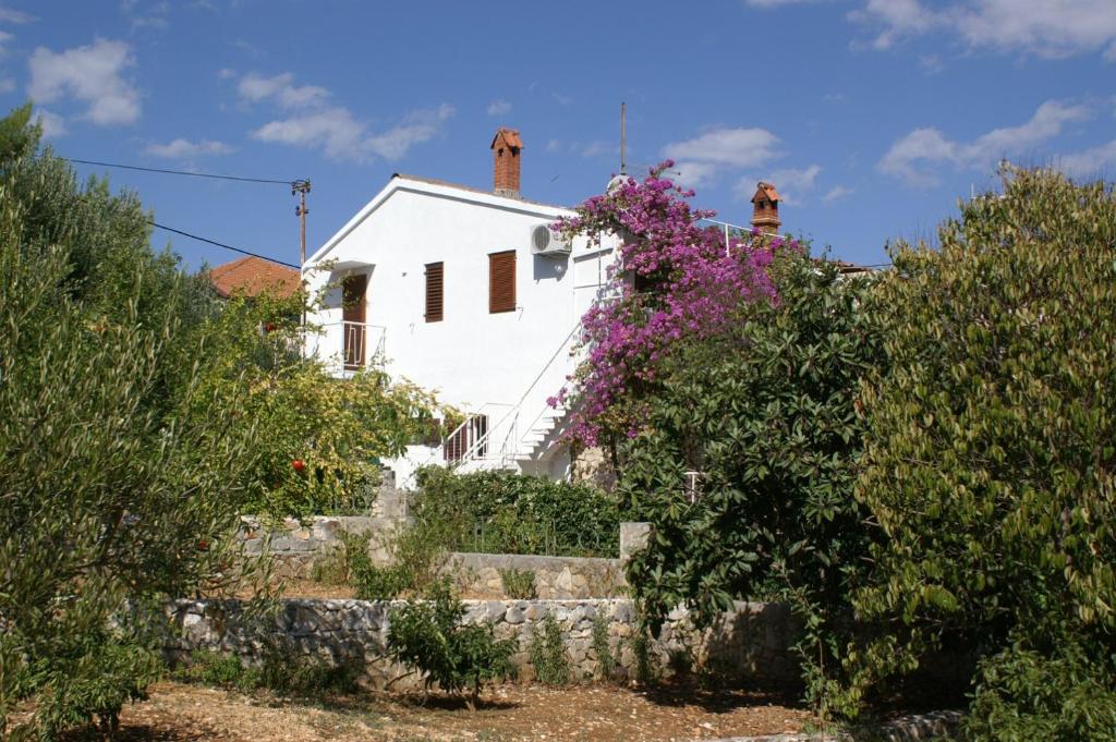 a white house with a bunch of flowers at Apartments by the sea Seget Vranjica, Trogir - 1037 in Seget Vranjica