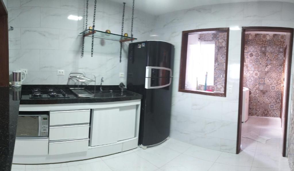 uma cozinha com uma geladeira preta e uma pia em No coração de Boa Viagem em Recife