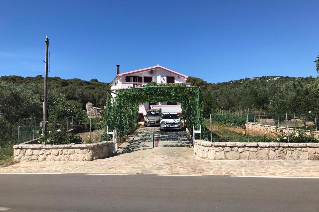 a house with cars parked in front of a driveway at Apartments with a parking space Kraj, Pasman - 819 in Tkon