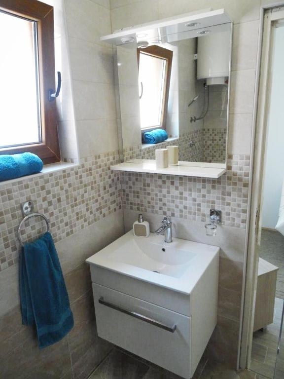 W łazience znajduje się umywalka, lustro i wanna. w obiekcie Apartment Biograd na Moru 860b w Biogradzie na Moru