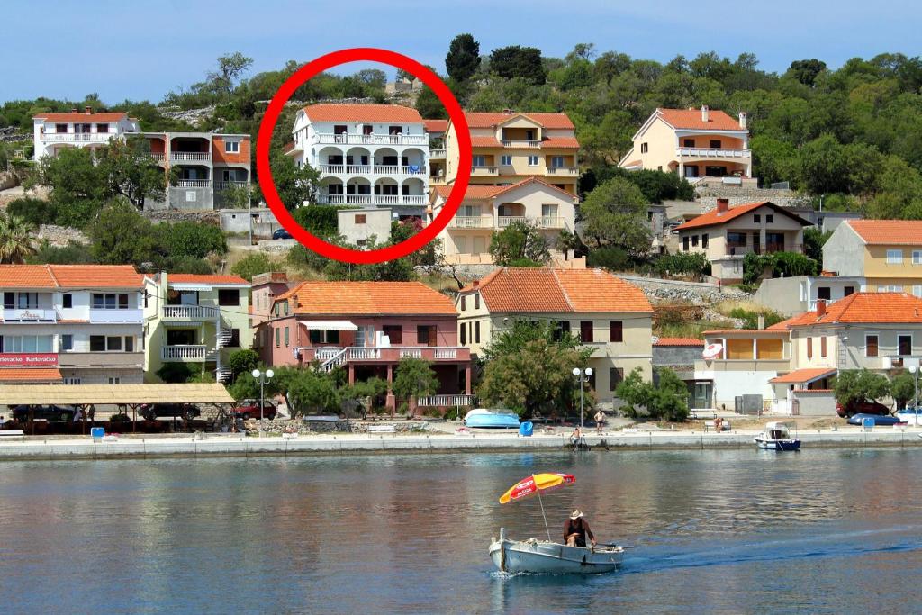 eine Person in einem Boot im Wasser mit einem roten Kreis in der Unterkunft Apartment Sali 890e in Sali