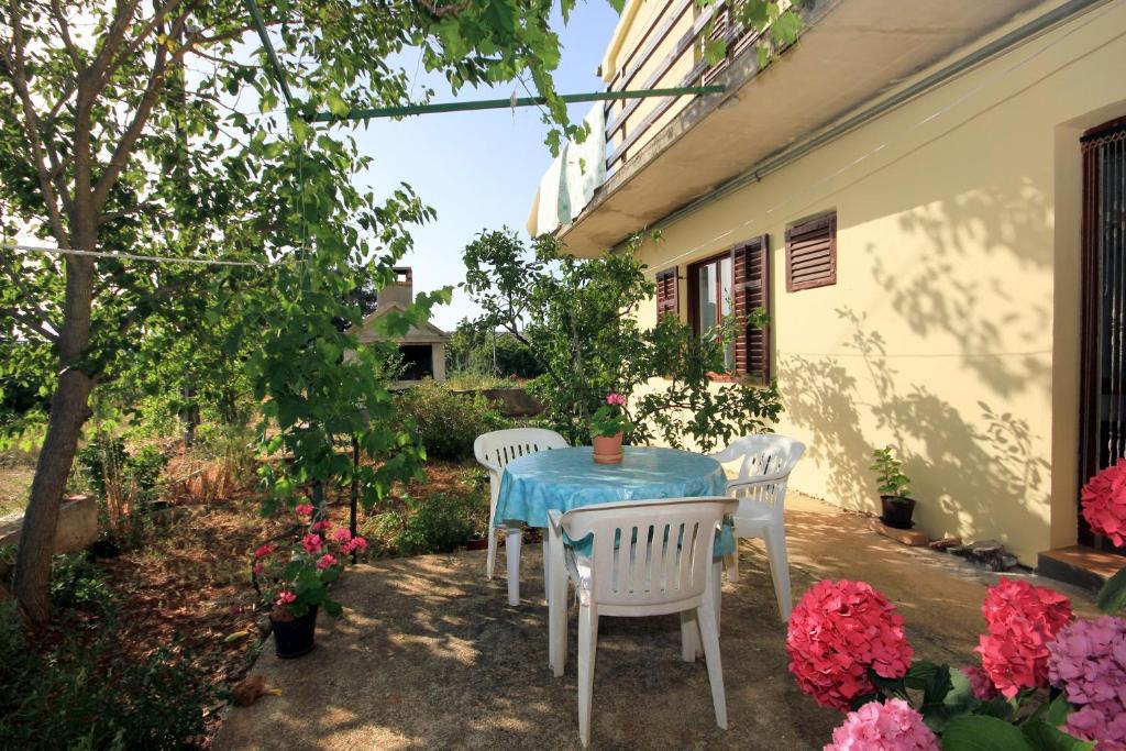 a table and chairs sitting on a patio with flowers at Apartment Zaglav 878a in Zaglav