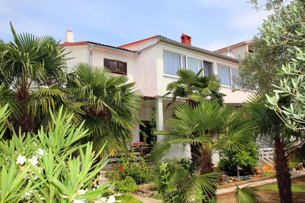 uma casa grande com palmeiras em frente em Family friendly seaside apartments Vodice - 928 em Vodice