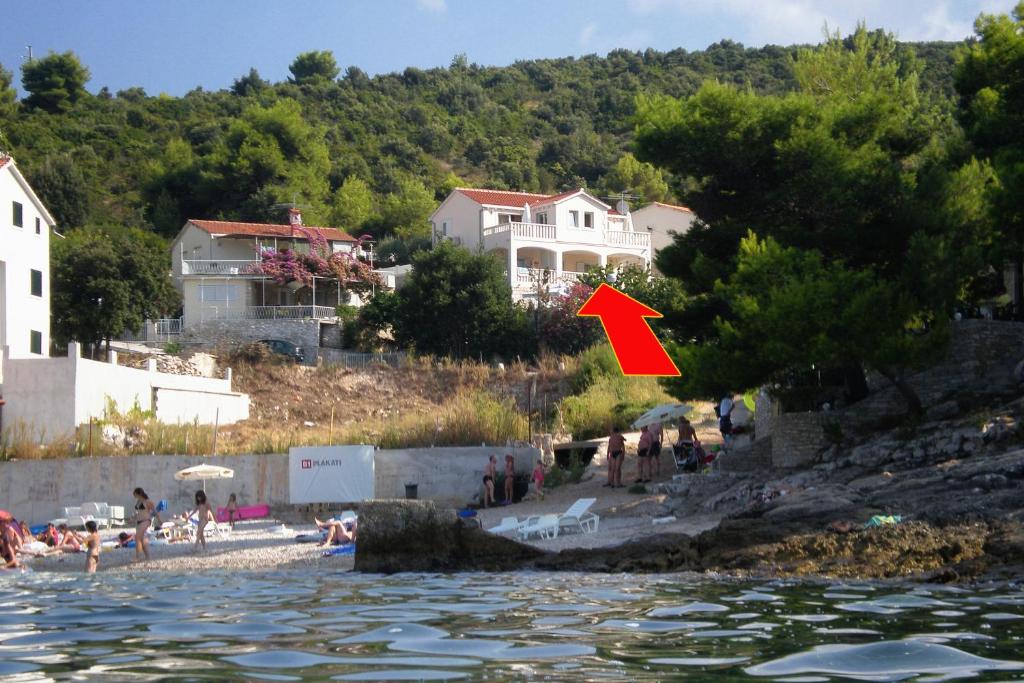 a red arrow pointing to a group of people on a beach at Apartments by the sea Postira, Brac - 705 in Postira