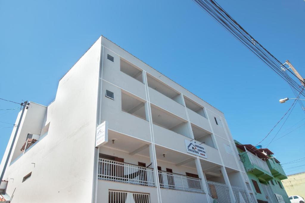 un edificio blanco con una grúa en Souza Reis Apart - Unidade 1, en São Thomé das Letras