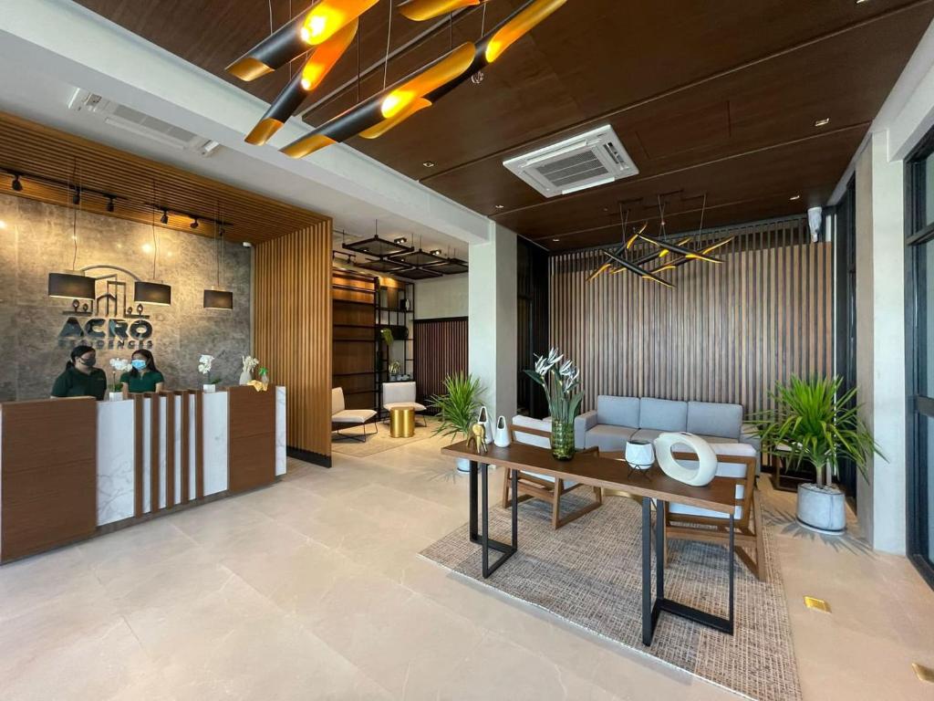 an office lobby with a reception desk and a table at Acro Residences in Guiguinto