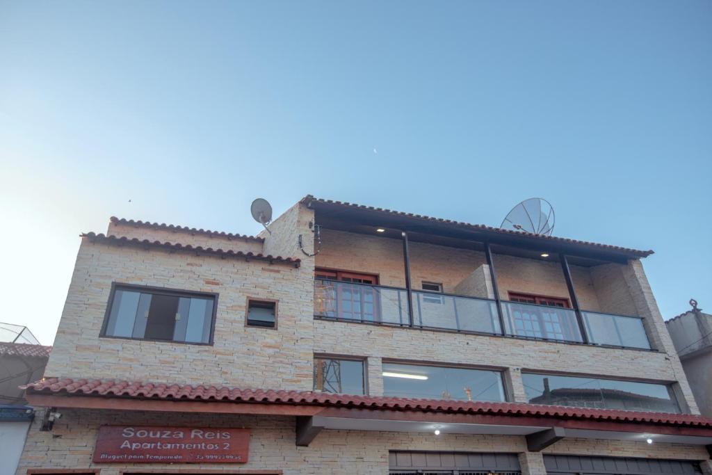 a building with a balcony on the side of it at Souza Reis Apart - Unidade 2 in São Thomé das Letras