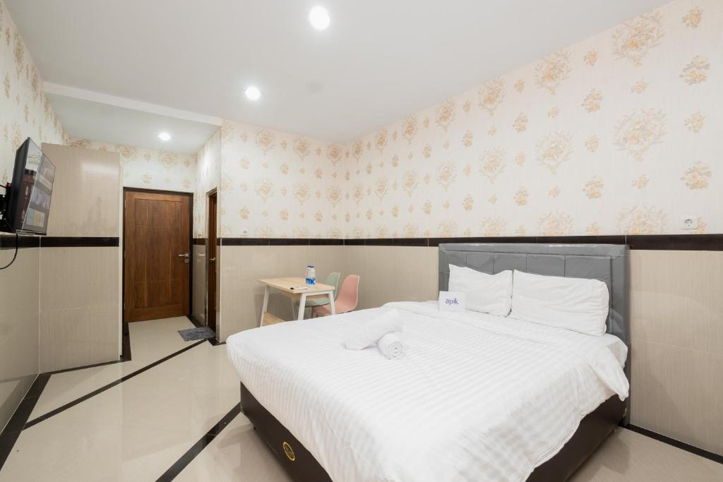 een slaapkamer met een groot wit bed en een keuken bij Apik GM 6 Sawah Besar in Jakarta