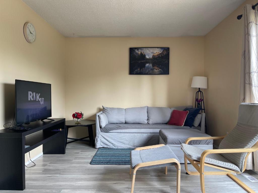 sala de estar con sofá y TV en MT Pleasant NW 2 bedrooms Suite 500AB, en Calgary