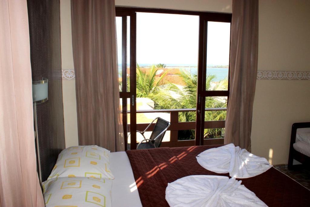 a bedroom with a bed with a view of a balcony at Pousada Recanto do Sal in Salinópolis