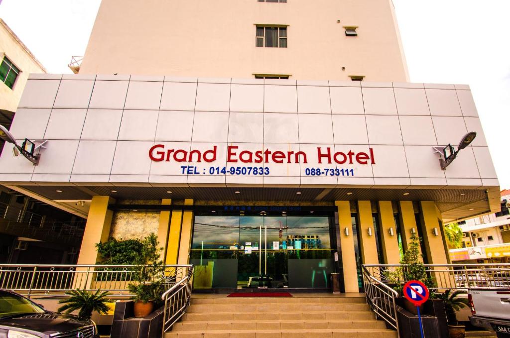 Un gran hotel del este con coches aparcados fuera de él en GRAND EASTERN HOTEL SDN BHD en Kota Kinabalu