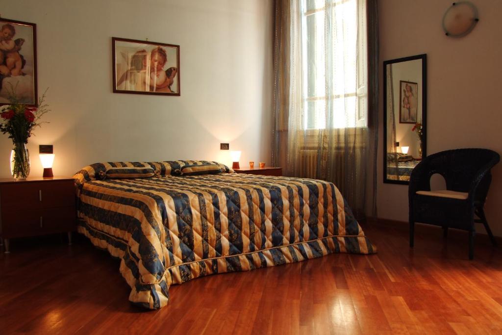 a bedroom with a bed and a chair and a window at Bellini B&B in Florence