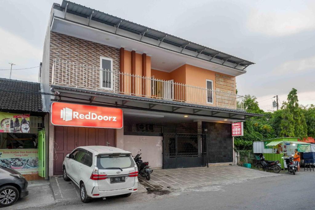 un coche blanco estacionado frente a un edificio en RedDoorz Syariah near RS Mitra Keluarga Tegal, en Tegal