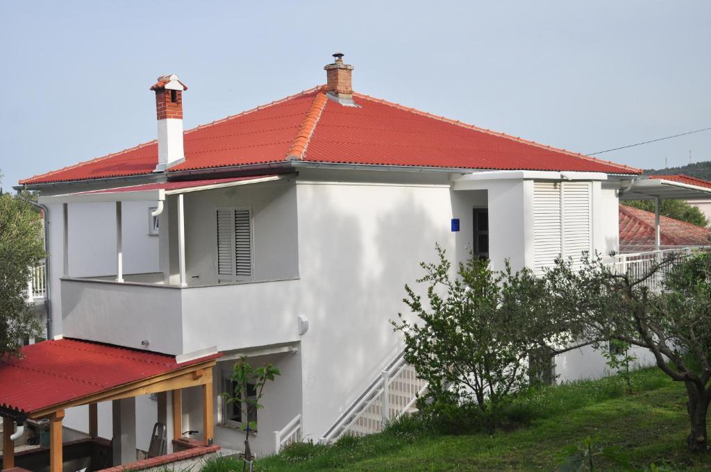 a white house with a red roof at Rooms by the sea Rab - 18786 in Rab