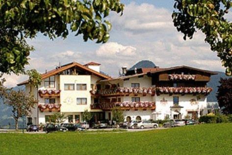 un gran edificio con coches estacionados frente a él en Gasthof und Hotel Rieder GmbH, en Jenbach