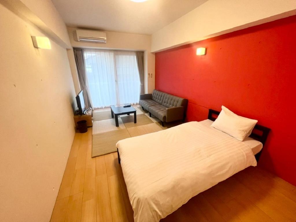 a bedroom with a bed and a red wall at Hamamoto Palace Taniyama - Vacation STAY 11251 in Kagoshima