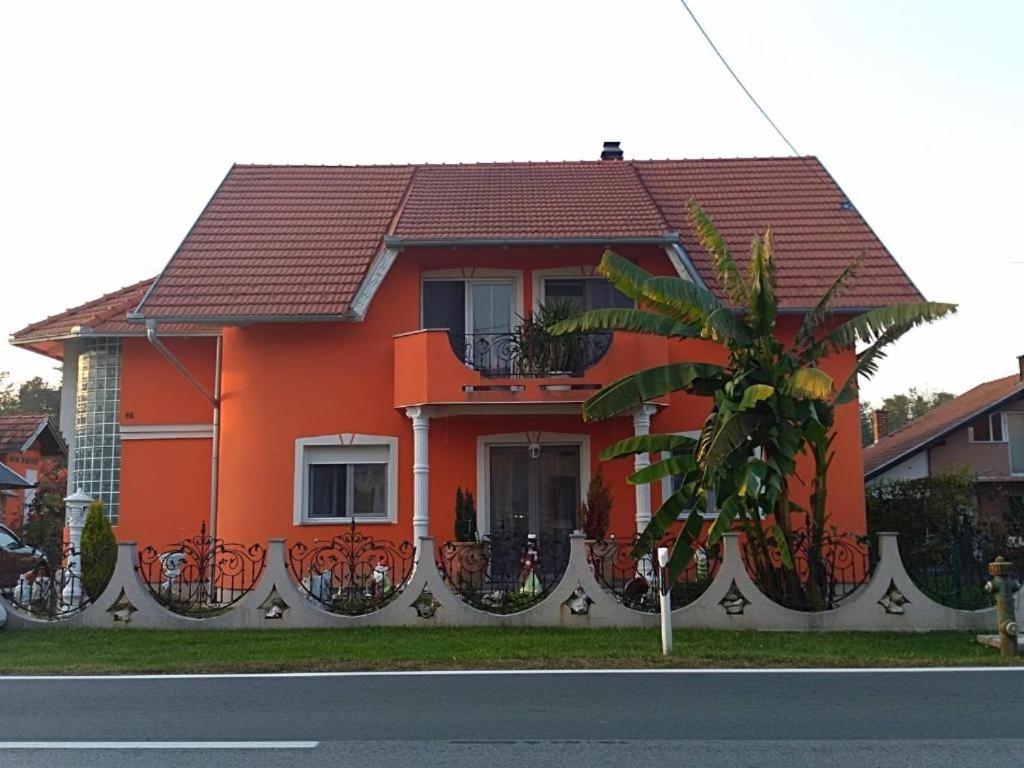 GarešnicaにあるApartments with a parking space Garesnica, Bjelovarska - 18833のヤシの木が目の前にあるオレンジの家