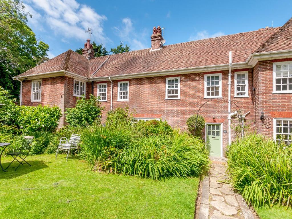 a large red brick house with a yard at Woodlands By The Sea Cottage in Deal