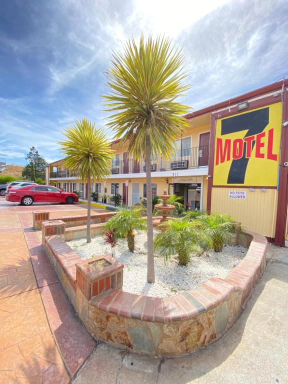un hôtel avec des palmiers devant un bâtiment dans l'établissement Motel 7 - Near Six Flags, Vallejo - Napa Valley, à Vallejo