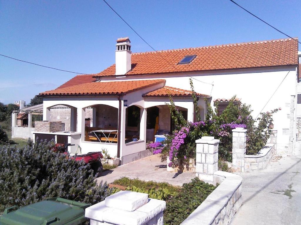 a white house with a red roof at Holiday house with a parking space Olib - 18805 in Olib