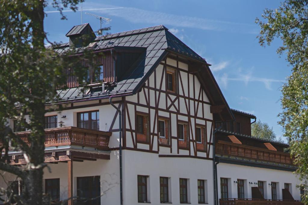 a large white building with a black roof at Pila Kvilda in Kvilda