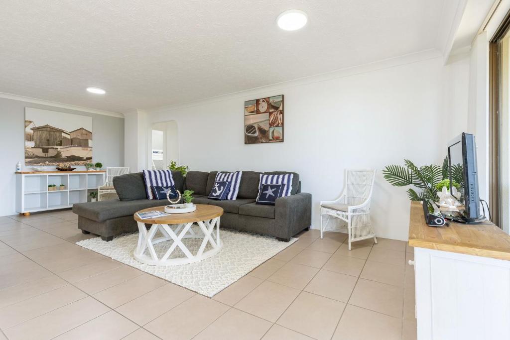 a living room with a couch and a table at Pinnacle 202 in Forster