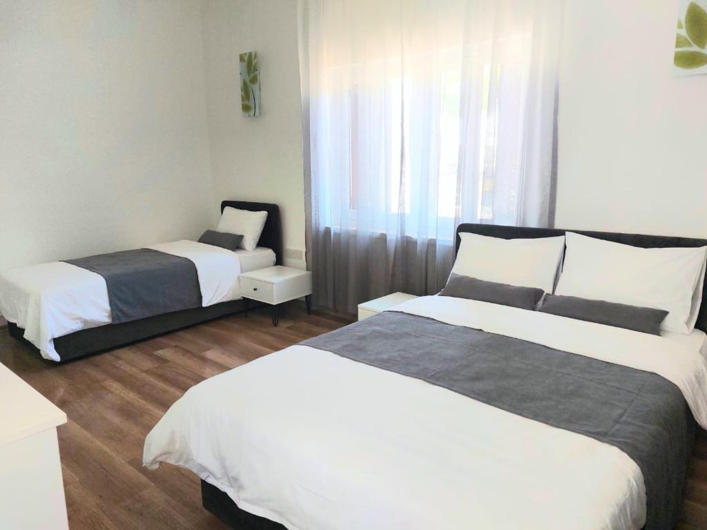 a hotel room with two beds and a chair at Secret Garden Guest House 02 in Famagusta