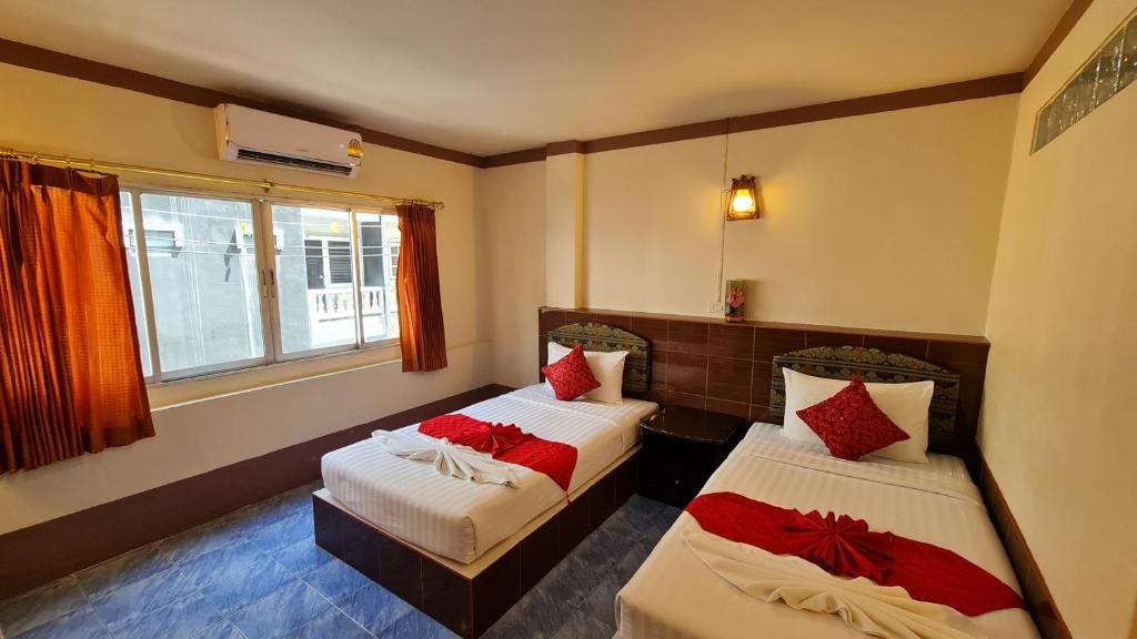 a room with two beds with red pillows at Vech Guesthouse Patong in Patong Beach