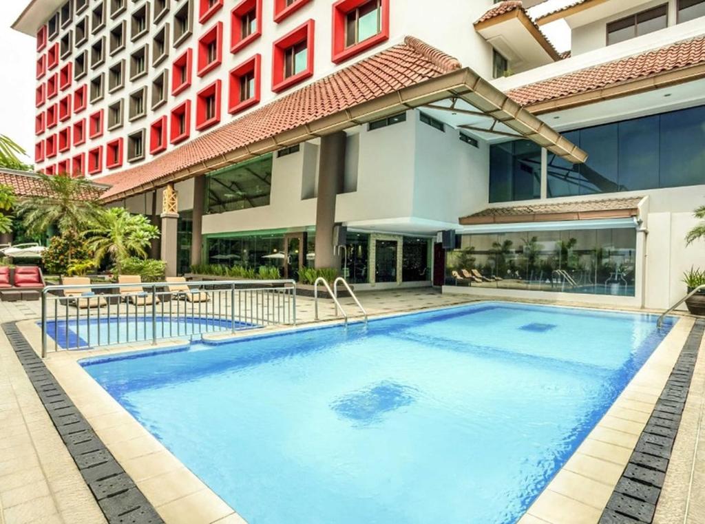 a large swimming pool in front of a building at Tamarin Hotel Jakarta manage by Vib Hospitality Management in Jakarta