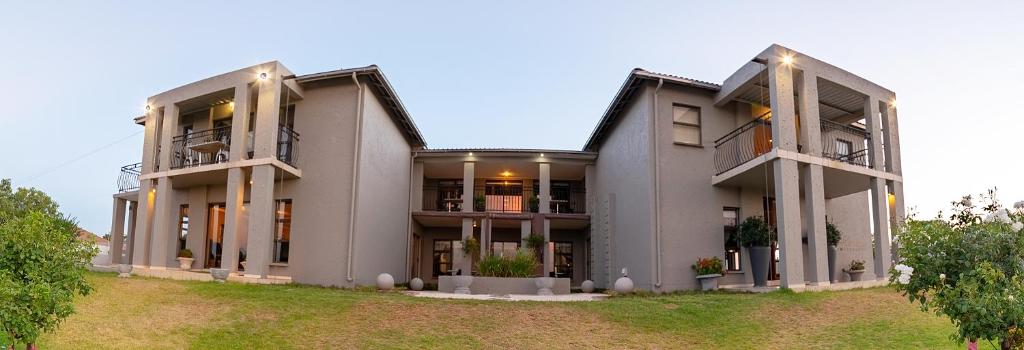 un gran edificio gris con 2 balcones en Altissimo Guesthouse, en Bloemfontein