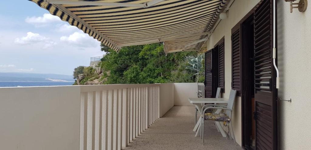 a balcony with a table and a view of the ocean at Apartments by the sea Pisak, Omis - 1018 in Pisak