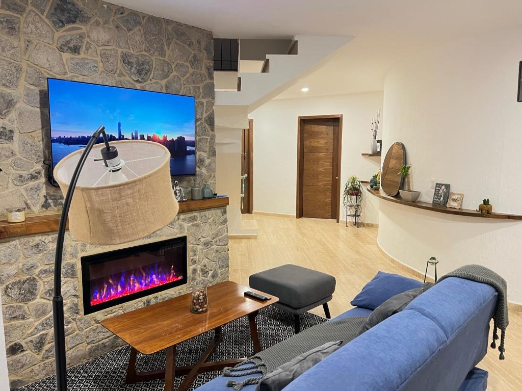 a living room with a blue couch and a fireplace at Loft Santiago Val’quirico in Tlaxcala de Xicohténcatl