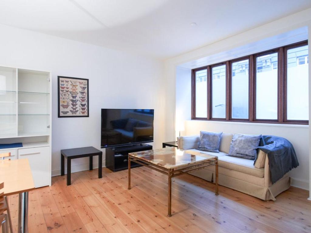 sala de estar con sofá y TV en Sanders Park - One-Bedroom Apartment Near a Huge City Park en Copenhague