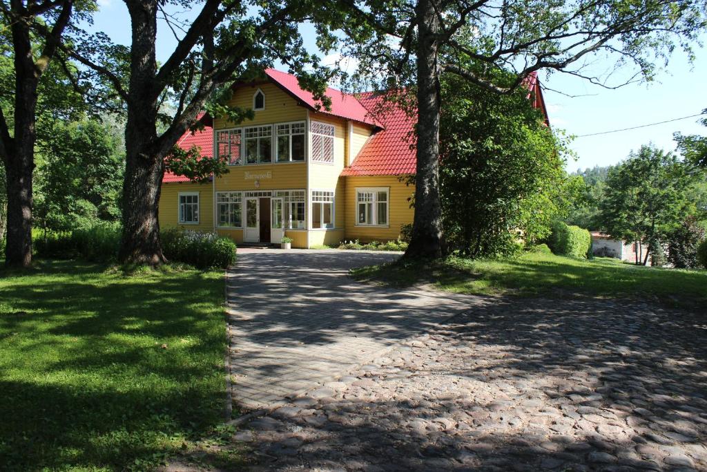 una casa amarilla con techo rojo en Nurmeveski Guesthouse, en Nurme