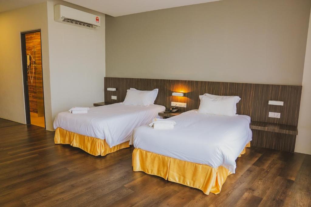Postel nebo postele na pokoji v ubytování Roxy Hotel Serian