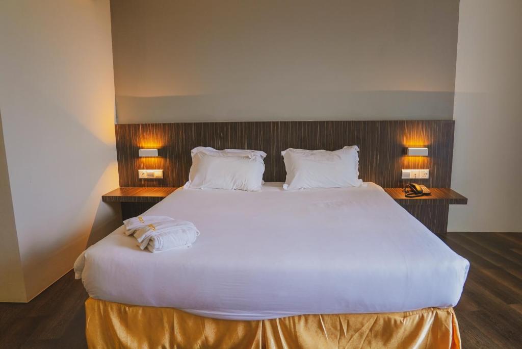 Postel nebo postele na pokoji v ubytování Roxy Hotel Serian