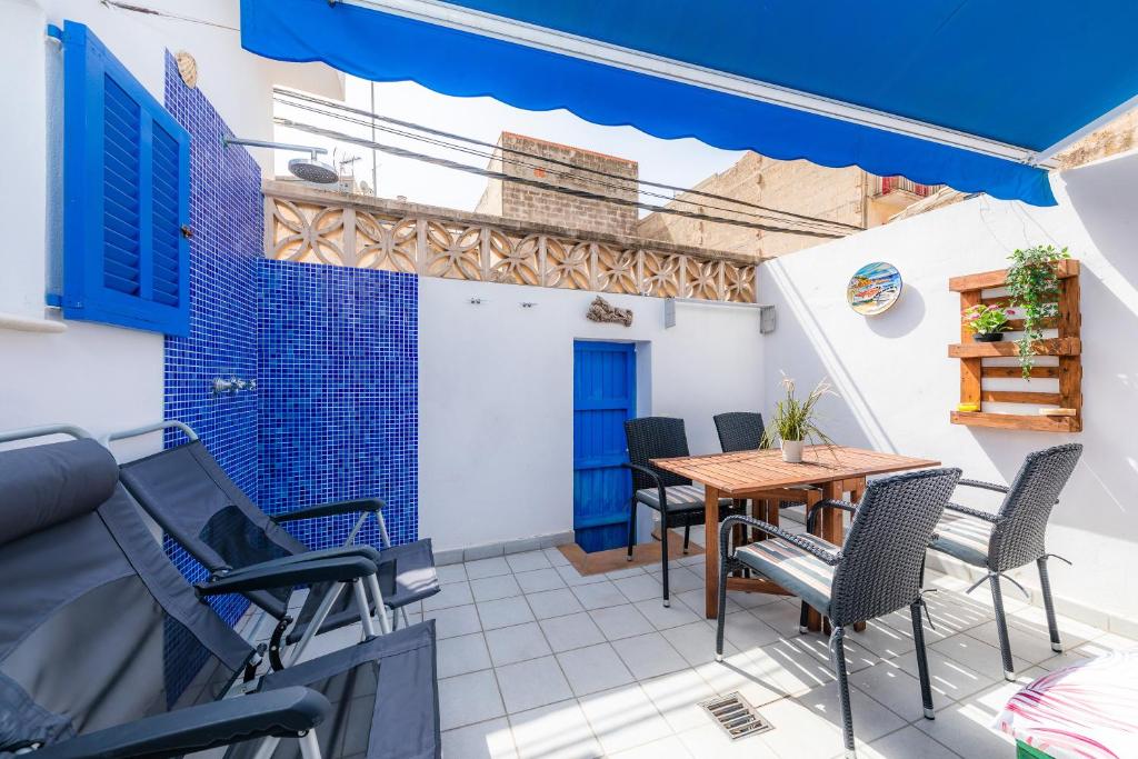 a patio with a wooden table and chairs at Es Cantonet in Porto Cristo