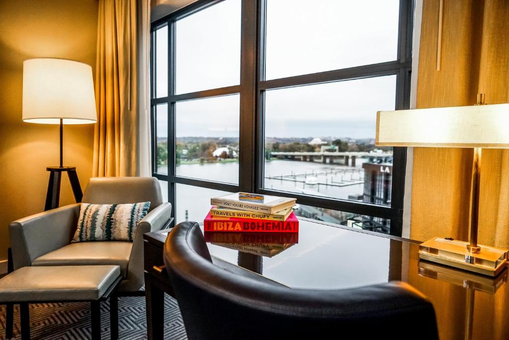 ein Wohnzimmer mit einem Tisch und einem großen Fenster in der Unterkunft InterContinental - Washington D.C. - The Wharf, an IHG Hotel in Washington