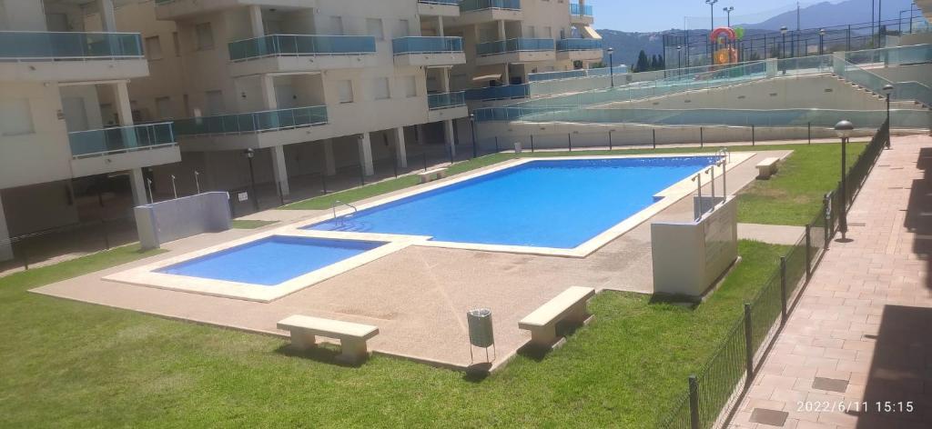 una grande piscina sul lato di un edificio di Apartamento nuevo en la playa de Piles a Piles