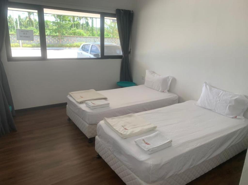 2 camas en una habitación con ventana en MF Roxy Beach Townhouse Sematan Private Unit L31 en Sematan