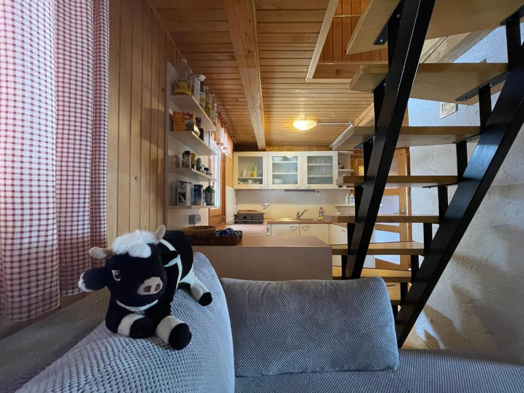 Une vache farcie assise sur un canapé dans une pièce dans l'établissement Velika Planina Koča Kekec, à Stahovica