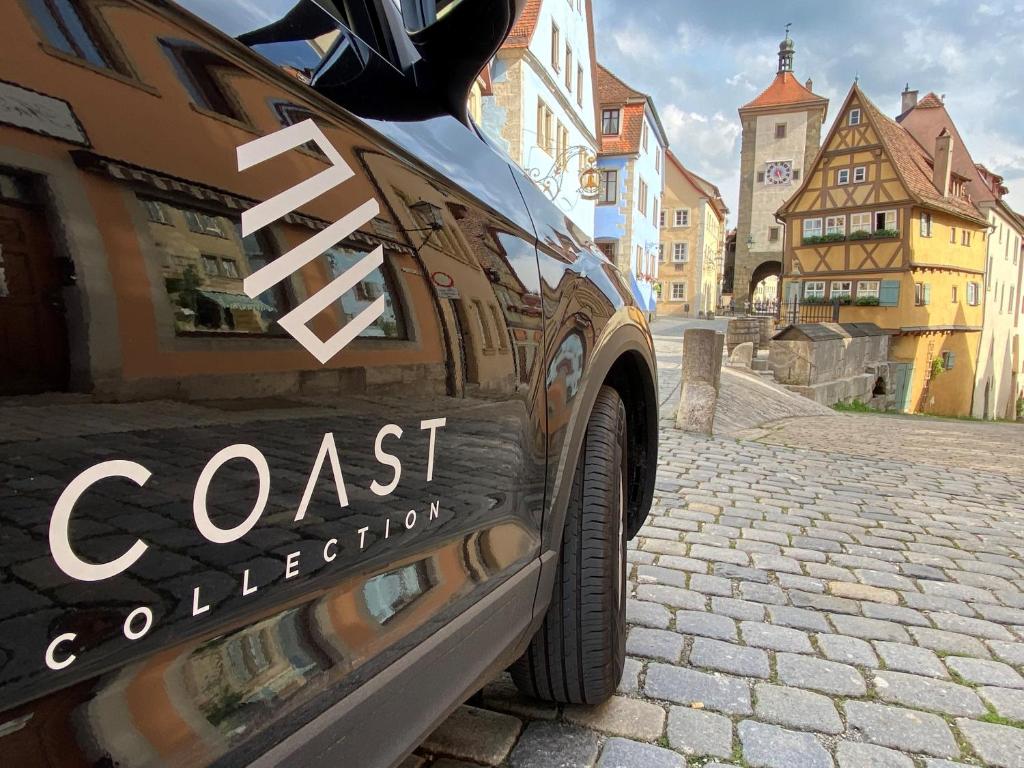 a black car parked on a cobblestone street at Hotel Eisenhut in Rothenburg ob der Tauber