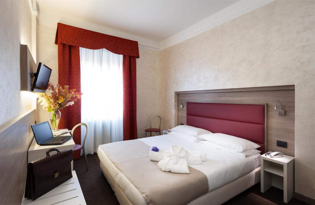 Una habitación de hotel con una cama con toallas. en Hotel Gamma, en Milán