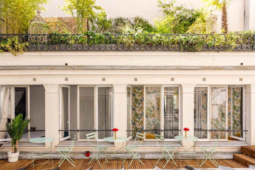 une maison avec un balcon orné de fleurs rouges. dans l'établissement Cosy 5 bedrooms with patio - Louvre Museum, à Paris