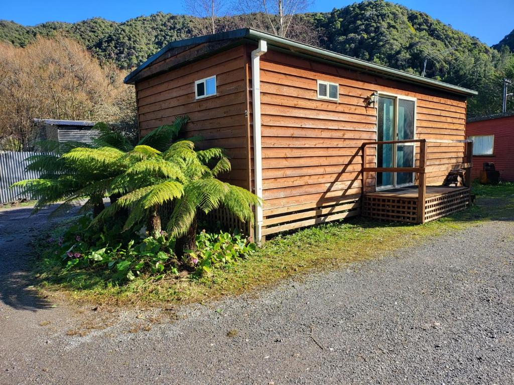 a small house with a palm tree in front of it at Queenstown Copper Country Cabins in Queenstown