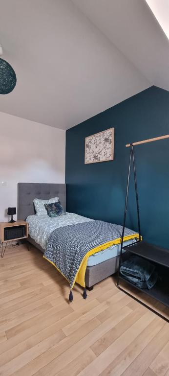 1 dormitorio con cama y pared azul en Enjoy en Champagne au calme milieu des vignes JO Paris 2024, en Dormans
