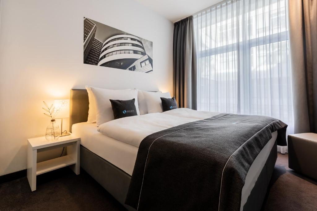 a hotel room with a large bed and a window at Select Hotel Berlin Gendarmenmarkt in Berlin